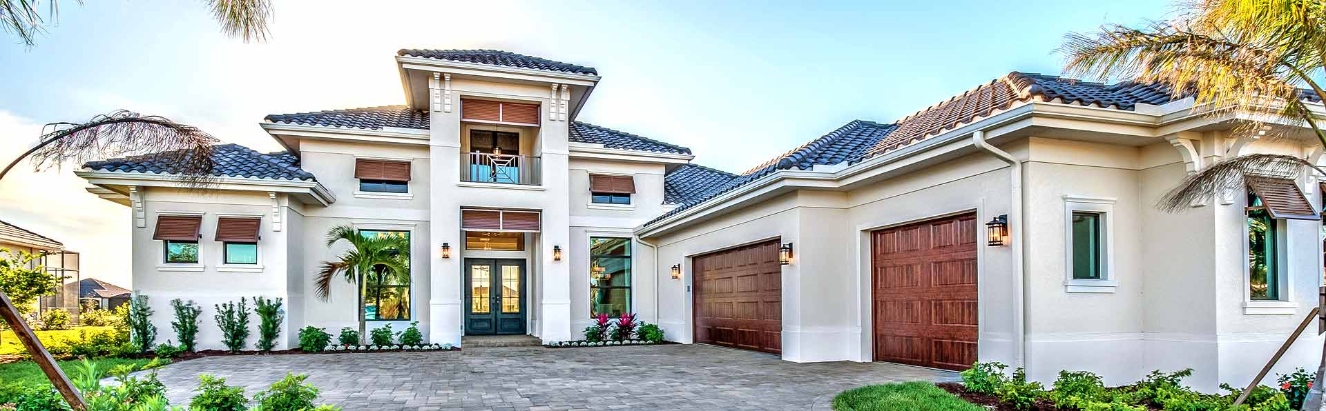 Large one-story Florida style house with tile roof, 3 car garage and pavered driveway