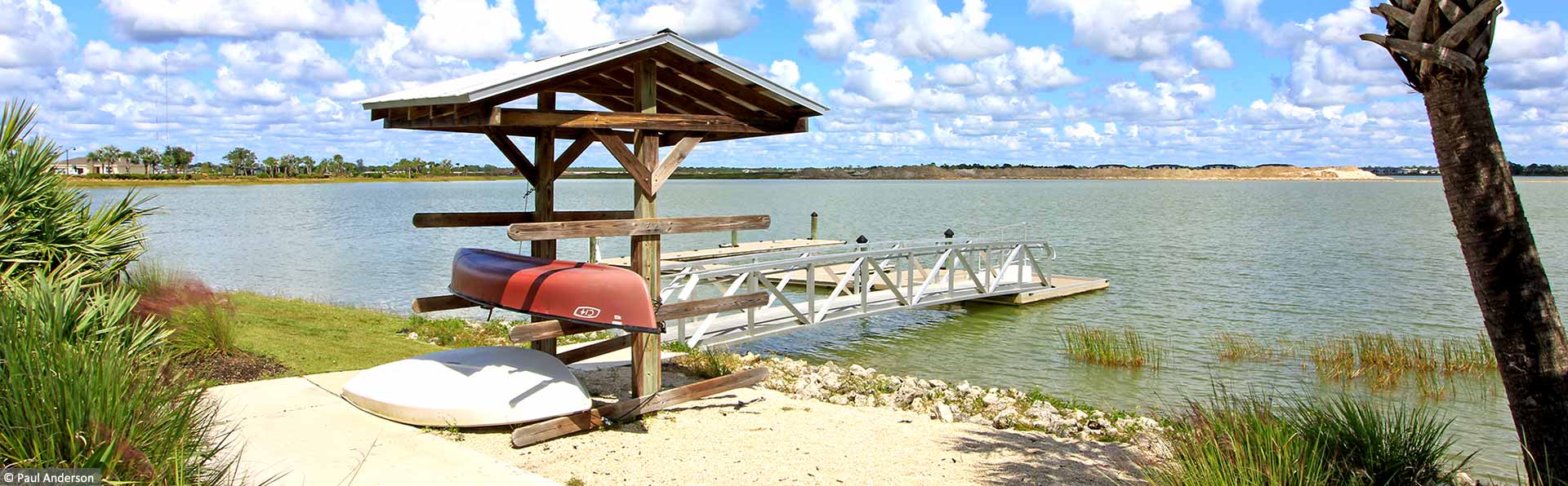red kayak on stand next to water