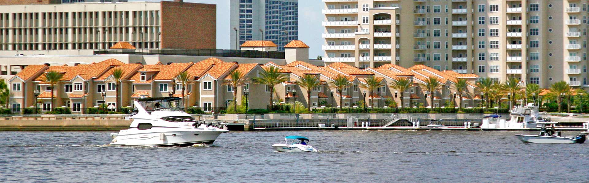 small watercraft boats on a river next to condos