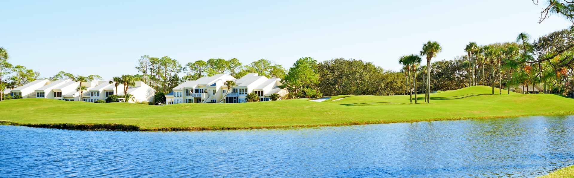 florida golf course next to water and two-story condos