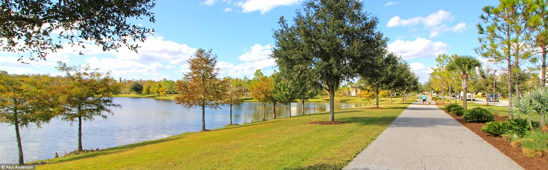 nature trail next to large lake with fall colors on trees
