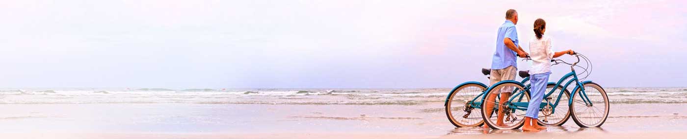 senior florida couple on bicycles on a beach
