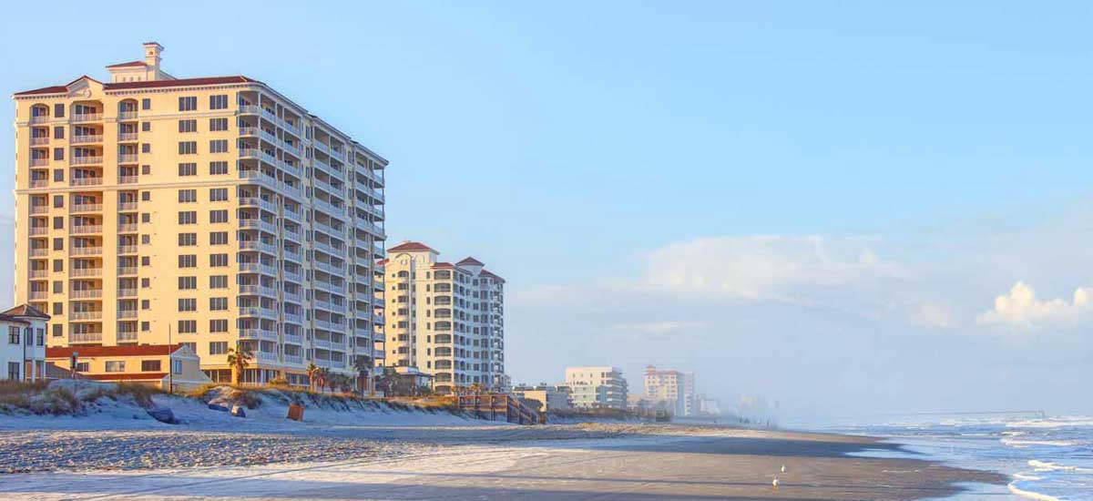 12 story condos overlooking Atlantic ocean waves and sand at sunrise