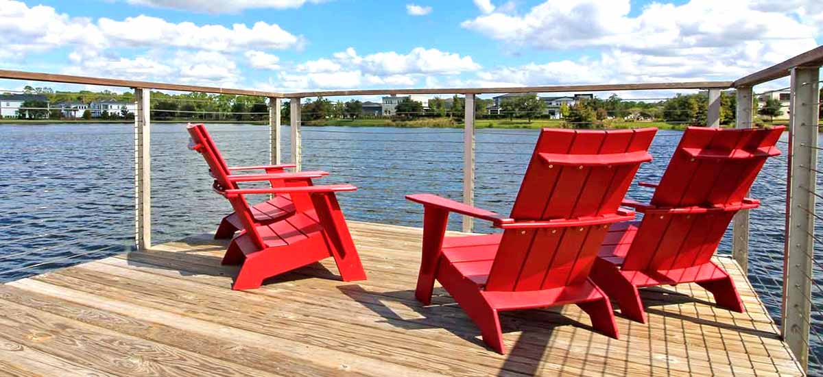 red beach chairs on wooden deck overlooking water