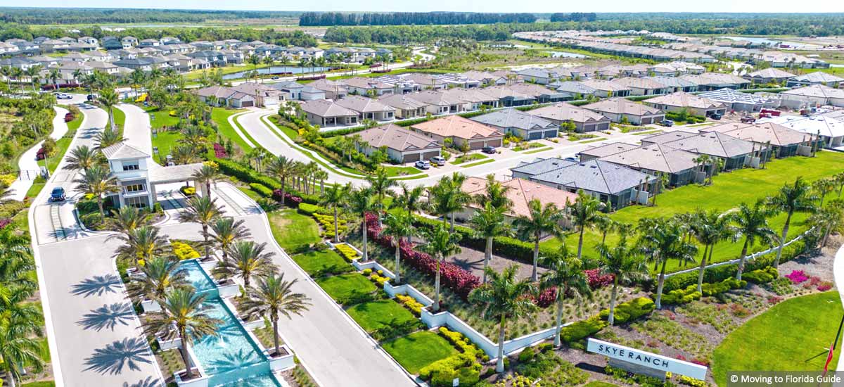 community entrance with ponds, signage and palm trees