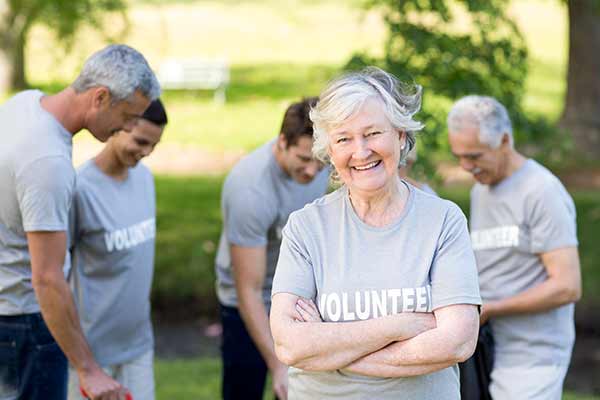 senior woman wearing a light gray volunteer tee shirt