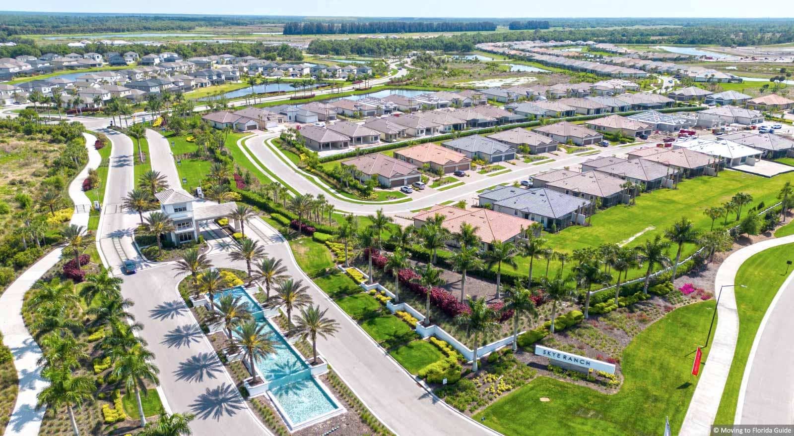 fountains and tropical landscape leading up to gated community entrance