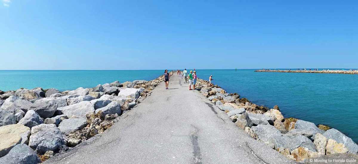walkable paved pathway exptending into a large body of water